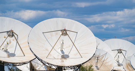 Close-up view of multiple large satellite dishes at a ground telecommunication station