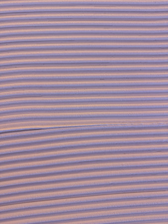 Textured surface with vertical beige lines and soft shadows, abstract architectural background