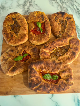 Su Mustazzeddu Typical Sardinian flatbread filled with tomato, onion, and fresh basil leaves