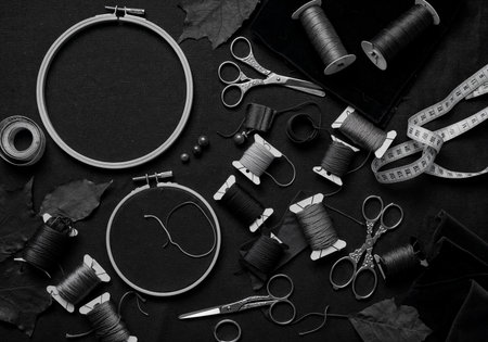 Top view of embroidery tools including hoops, colorful threads, scissors, and fabric swatches