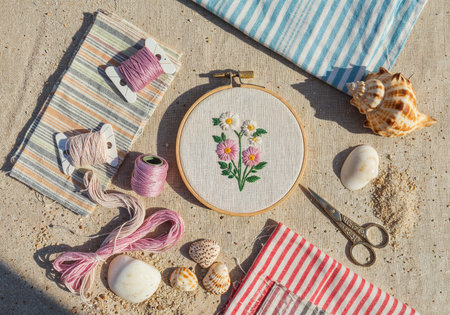 Top view of embroidery tools including hoops, colorful threads, scissors, and fabric swatchesの写真素材