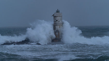 Powerful ocean waves smashing into isolated lighthouse during heavy sea storm
