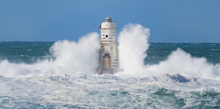 Powerful ocean waves smashing into isolated lighthouse during heavy sea stormの写真素材