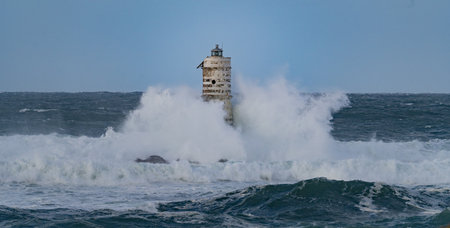 Powerful ocean waves smashing into isolated lighthouse during heavy sea storm