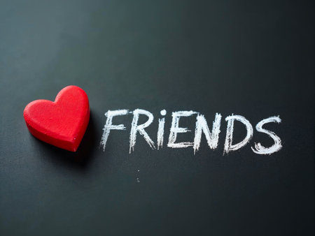 Red heart next to glowing Friends text on dark backgroundの素材