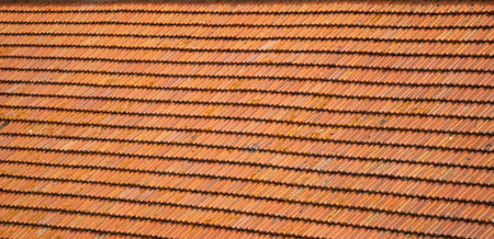 Closeup of old red clay roof tiles showing texture, weathering and natural details