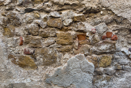 Rough stone wall displaying a textured pattern, ideal for backgroundsの写真素材