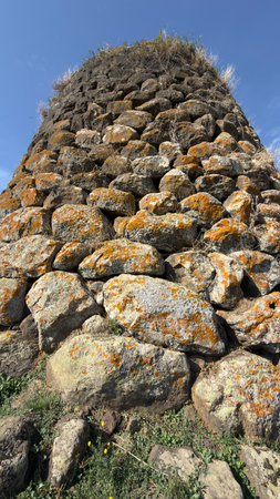 View of the Nuraghe Sa Jua archaeological site in Aidomaggiore, Sardinia, with basalt stones and surrounding countrysideの写真素材