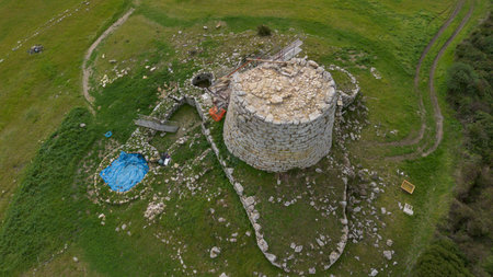 Aerial view of ancient Nuraghe under restoration in Sardinian countryside
