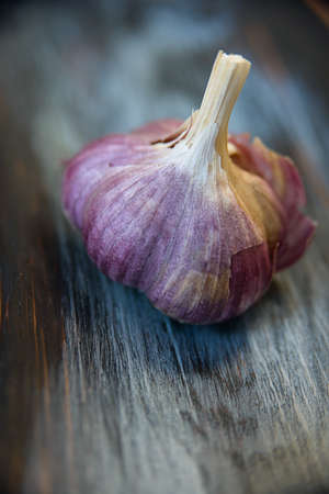 head of garlic on textured cutting Board closeup の写真素材
