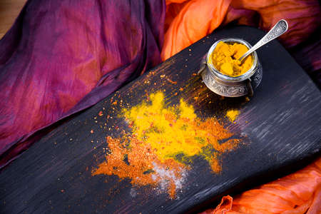 Turmeric with spices in a pepper pot on textured wooden Board in Oriental styleの写真素材