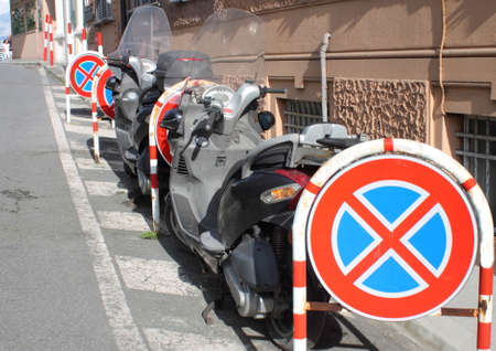 Prohibited parking is not respected with motorbikes parked between ban on cartelsのeditorial素材
