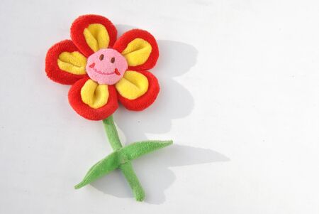 Plush smiling flower with shadow on white backgroundの写真素材