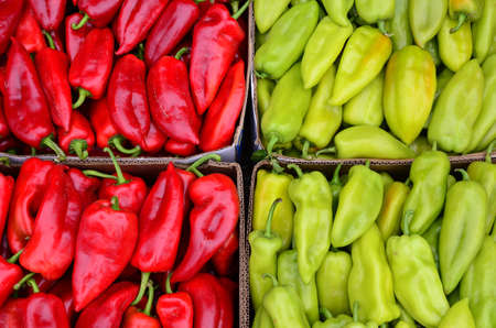 Full frame of red and green peppers background - heap of red and green peppers in cardboard box ready for saleの写真素材