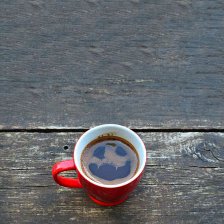 Terrible shape of ghost in cup of coffee on old oak tableの写真素材