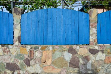 Blue wooden and stone fence, built in traditional Romanian wayの写真素材