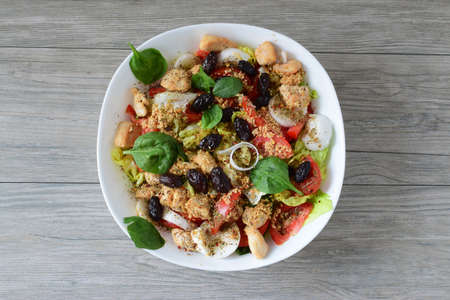 Healthy meal, Caesar salad in white ceramic bowl on grey wooden background, top view, close upの写真素材