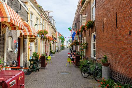 Very nice old alley with flowers in the old center of Delft, the Netherlands. This alley is called the trumpet street.のeditorial素材
