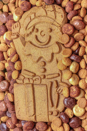 A chocolate letter S on a pile of dutch candy called Pepernoten, traditional sweets for the...