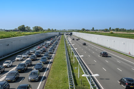 DELFT, NETHERLANDS - MAY 13, 2023 : Modern deepened motorway A4, traffic jam towards Rotterdam....