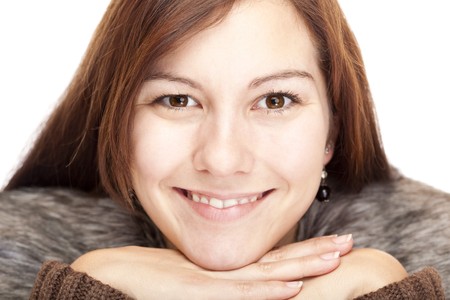 Beautiful young Woman with chin on hands smiling happy into camera. Isolated on white background. の写真素材