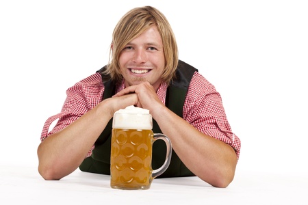 Man with lederhose and oktoberfest beer stein lying on floor. Isolated on white background.の写真素材