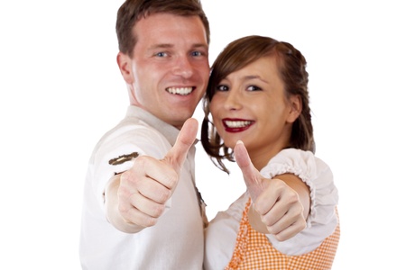 Successful Bavarian man and woman with dirndl hold thumbs up. Isolated on white background.の写真素材