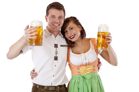 Bavarian man and woman in dirndl and lederhose with beer stein. Isolated on white background.の写真素材