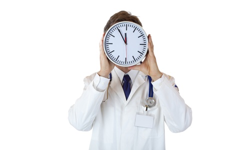 Stressed doctor with clock in front of face as sign of time pressure.Isolated on white background.の写真素材