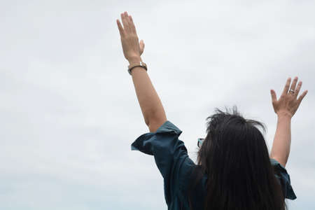 Girl rising up her hands feeling happyの写真素材