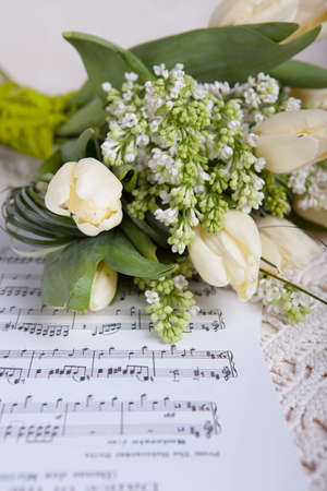 Bouquet of white tulips and white lilacs on a table in interiorの写真素材