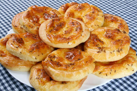 Cheese buns with caraway seeds on a white dish