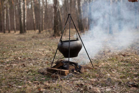 Cooking bogracs gulyas soup in a cauldron on fire in forestの写真素材