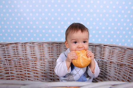 A tiny child eats a wicker basket in a basket woven from a wicker tree.