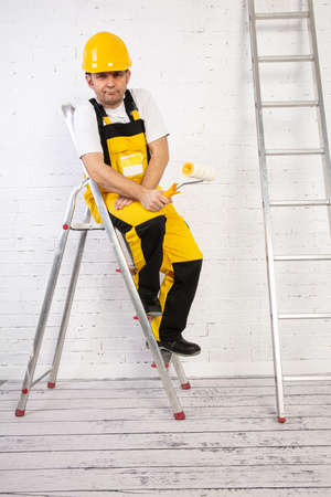A professional painter compact and ready to work at any time. He is wearing typical protective clothing used at the construction site.の写真素材
