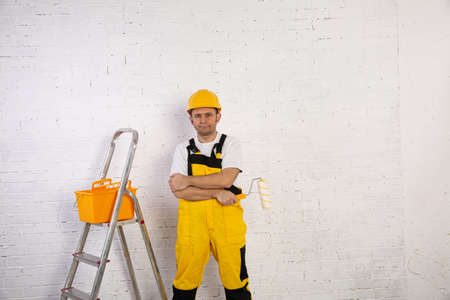 A professional painter compact and ready to work at any time. He is wearing typical protective clothing used at the construction site.の写真素材