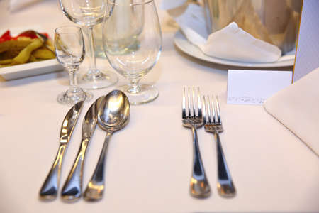 A huge table, covered with a white tablecloth with all the cutlery and food.の写真素材