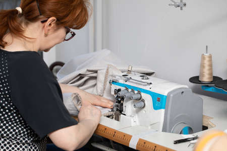 A seamstress with many years of experience in middle age works quickly and efficiently.の写真素材