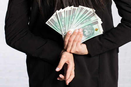 Behind her, the woman holds money as a surprise for the winner.