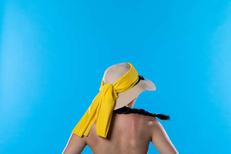 A big beach hat on his head during the hot summer against the blue sky.の写真素材