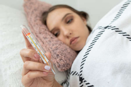 The thermometer showed a high body temperature, which indicates that the teenager is very sick.