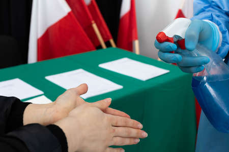 Female hands. Hand disinfection. Polling station. Presidential election in Poland.