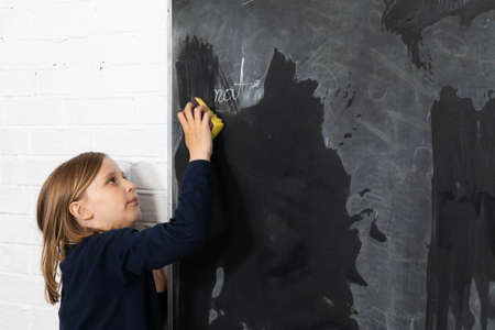 One girl from the class was appointed to wipe the wet sponge of the school board.の写真素材