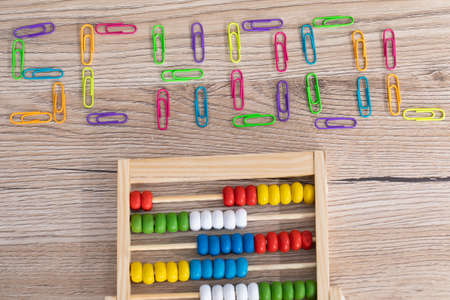 Lettering - school, made of colorful office paper clips. Board structure as a school desk top. Counters for counting.の写真素材