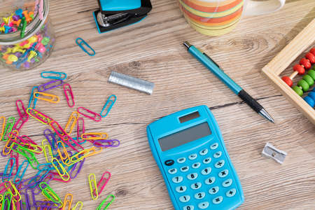 On the table top there are wooden abacus and an electronic blue calculator.の写真素材