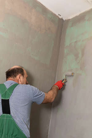 Bathroom renovation. Construction worker. Mineral moisture insulation. During work.の写真素材