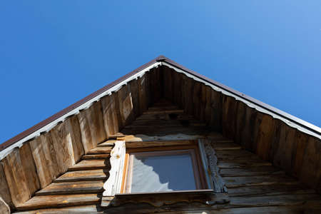 Wooden facade of the summer house. Clear blue sky on a sunny day.の写真素材