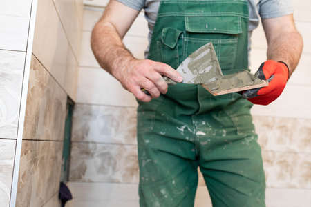 Thick cement based adhesive. A professional employee for interior finishing. Tiles - ceramic tile.