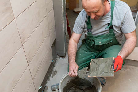 Thick cement based adhesive. A professional employee for interior finishing. Tiles - ceramic tile.