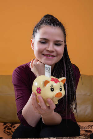 The first money saved, even the smallest ones, gives reason to be happy and proud. A young adult successfully saves and invests the earned money.の写真素材